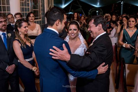 pai da noiva sorri abraça noivo noiva sorri convidados observam'