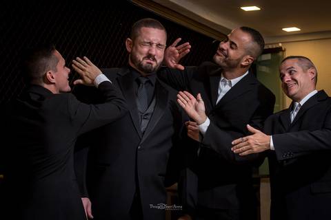 noivo recebe tapas dos padrinhos que sorriem '