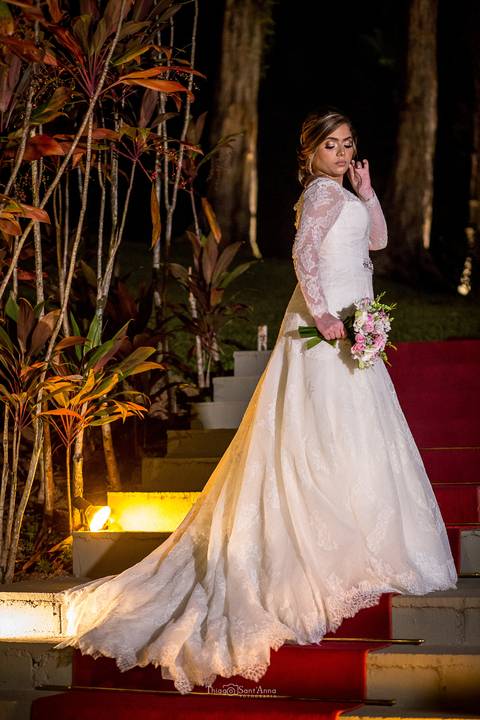 noiva vestido buque escadaria tapete vermelho vegetação ambiente externo'