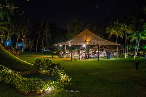 ambiente externo tenda iluminada vegetação gramado coqueiros'