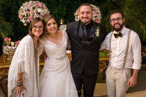 noivos posam com convidados'