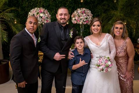 noivos posam com convidados'