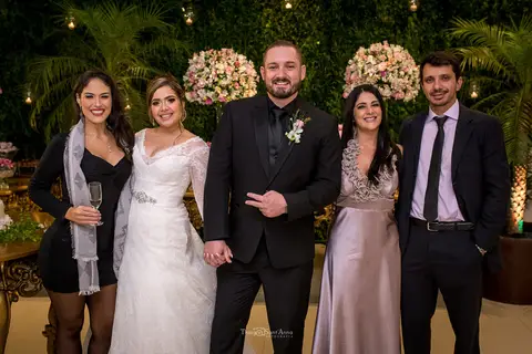 noivos posam com convidados'