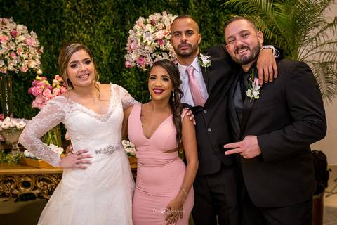 noivos posam com convidados'