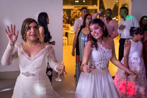 noiva dança com dama de honra convidados ao fundo'