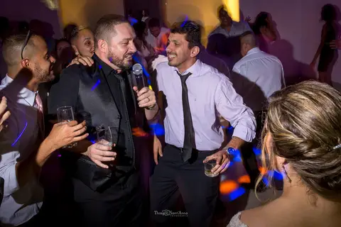 noivo canta ao microfone dança com padrinhos'