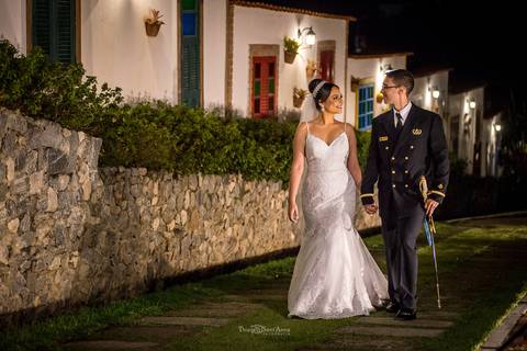 noiva e noivo caminham por rua de paralelo ao lado de casas rústicas portas e janelas coloridas'