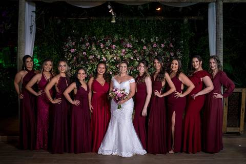 noiva e suas madrinhas vestido bordô parede flores tons de rosa ao fundo'