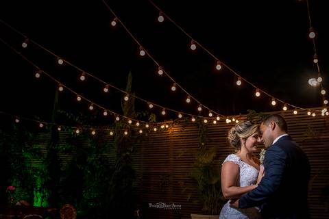 noivos se abraçam luzes penduradas decoração'