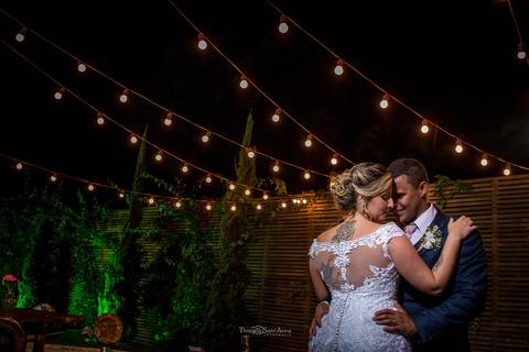 noivos se abraçam luzes penduradas decoração'