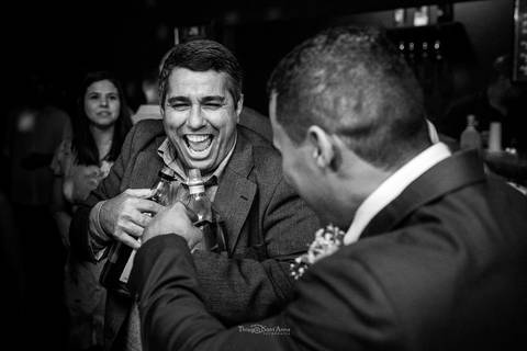 padrinho sorri segurando garrafas preto e branco'