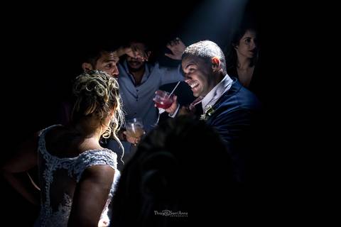 noivo sorri noiva dança convidados ao fundo'