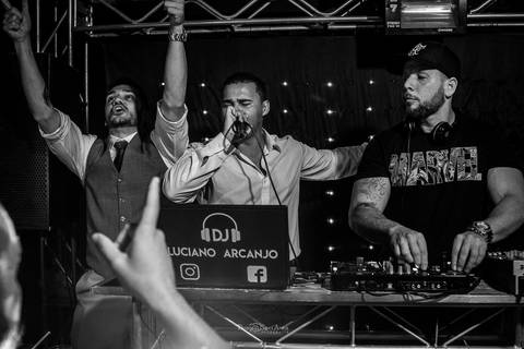 noivo canta no palco com DJ e padrinho preto e branco'