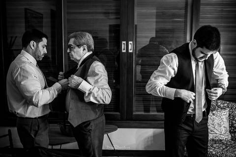 noivo pai e irmão se preparam para o casamento preto e branco'