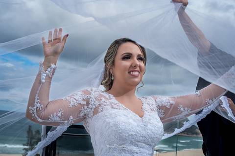noiva sorri sob o véu paisagem praia'