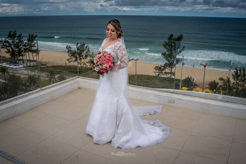 noiva sorriso buque flores tons de rosa vestido véu paisagem praia'
