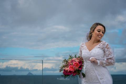 noiva sorriso buque flores tons de rosa vestido véu paisagem praia'