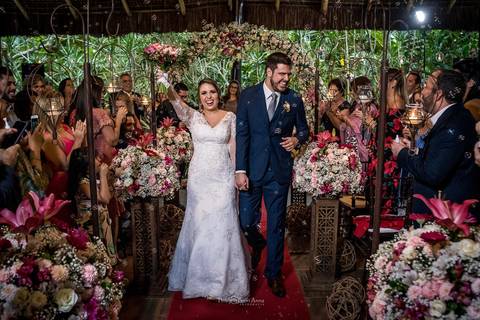 saída dos noivos decoração flores tons de rosa convidados ao fundo'