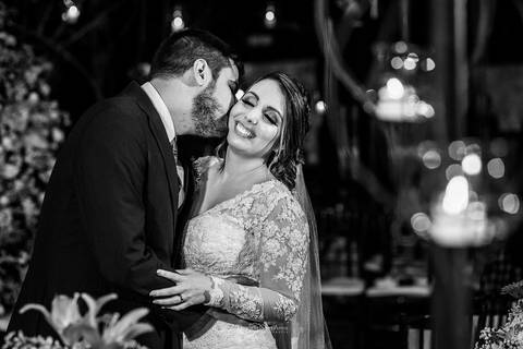 noivo beija rosto da noiva sorri '