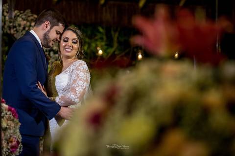 noivos se abraçam noiva sorri decoração flores tons de rosa'