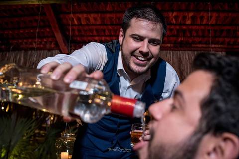 noivo derrama bebida na boca de convidado'