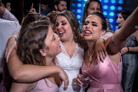 noiva canta abraçando madrinhas'