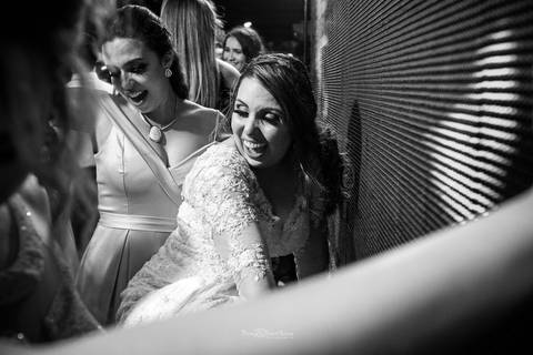 noiva sorri dançando com madrinha preto e branco'