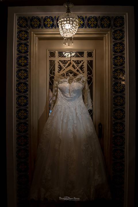 vestido da noiva pendurado em porta'