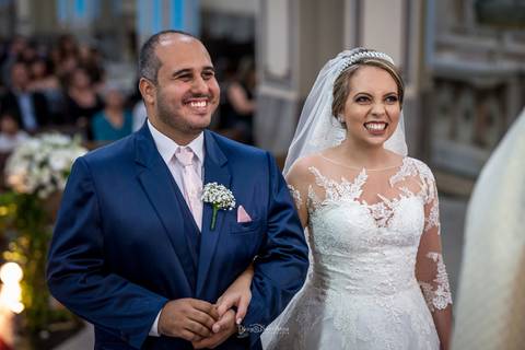 noivos sorrindo no altar '
