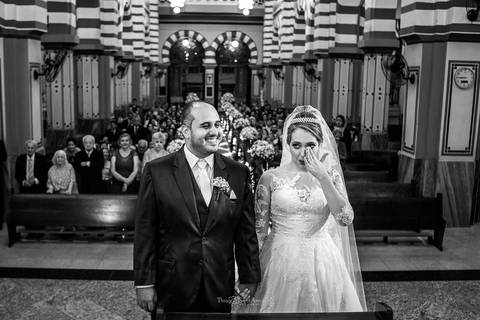 noivos rezando no altar igreja convidados ao fundo preto e branco'