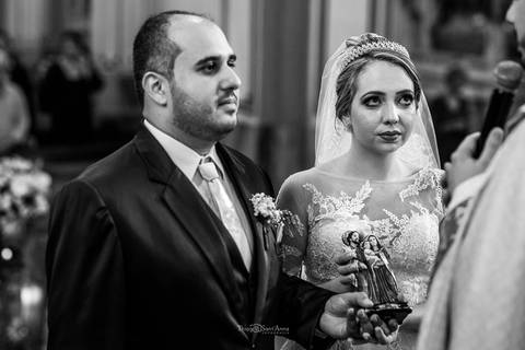 noivos atentos ao padre no altar preto e branco'