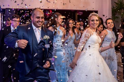 dança dos noivos sob o confete padrinhos ao fundo'
