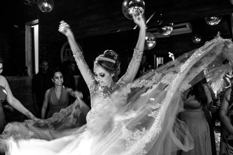 noiva dança na pista convidados ao fundo preto e branco'