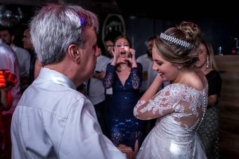 noiva dança com seu pai convidados ao fundo'