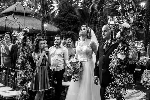 entrada da noiva com seu pai convidados observam de pé ambiente externo decoração flores preto e branco'