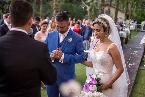 noivos altar fazem prece junto ao pastor convidados ao fundo'