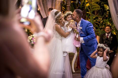 noiva levanta uma das damas de honra e noivos a beijam'