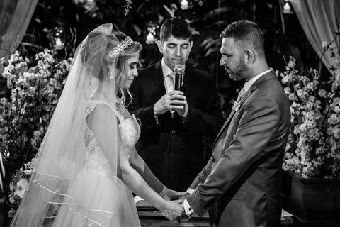 noivos realizam prece junto ao pastor altar preto e branco'