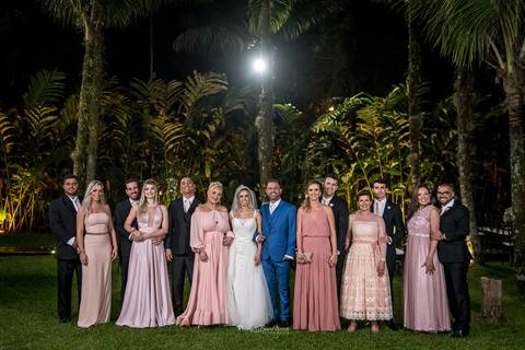 noivos posam junto aos padrinhos ambiente externo gramado árvores'