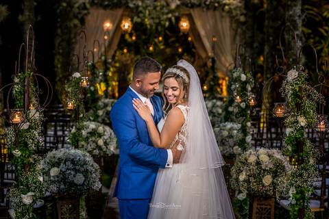 noivos abraçados noiva vestido véu noivo terno azul decoração flores brancas'