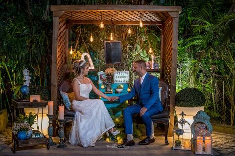 noivos sentados conversam ambiente externo vegetação estrutura de madeira móvel almofadas azul celeste'