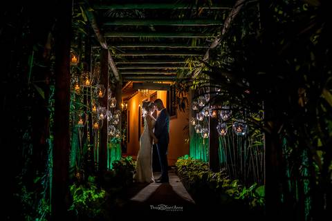 beijo dos noivos caminho de madeira vegetação luminárias decoração '