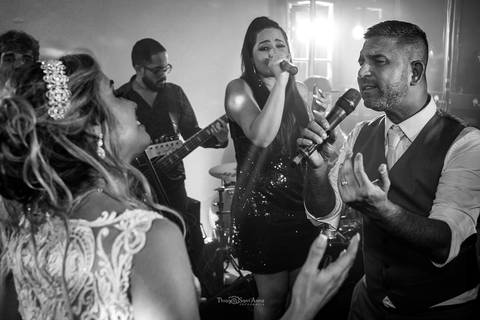noivo canta ao microfone com banda noiva sorri preto e branco'