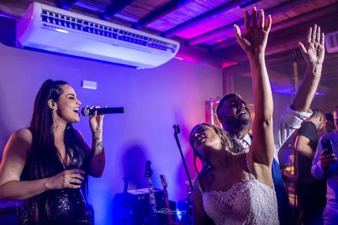 noivos dançam cantam estendem as mãos para o alto banda festa de casamento '