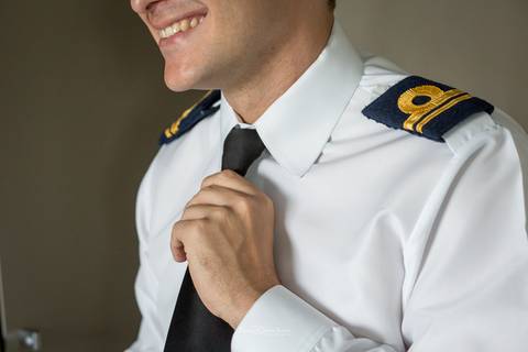 noivo se prepara para o casamento sorri ajusta gravata'