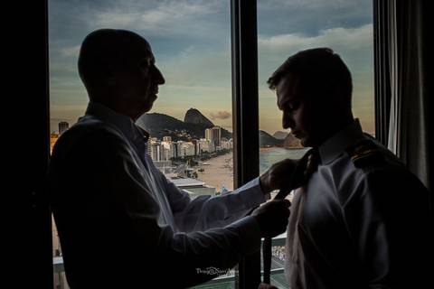 padrinho ajusta grava do noivo paisagem praia silhueta'