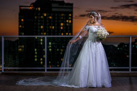 noiva véu vestido buque paisagem prédios anoitecer'