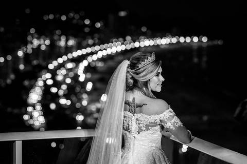 noiva de costas olha sobre o ombro vestido véu paisagem anoitecer preto e branco'