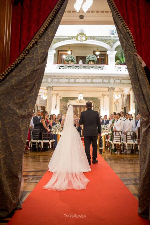 entrada da noiva e seu pai igreja tapete vermelho convidados observam de pé'