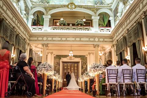 igreja convidados noivos no altar junto ao padre'